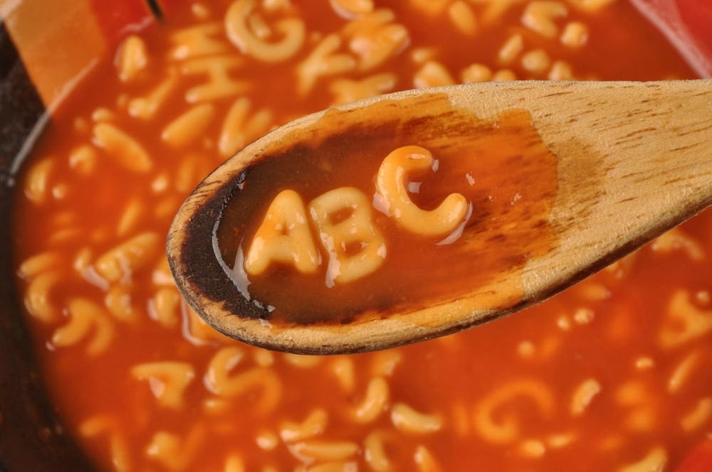 Photo of some alphabet soup, with a spoon holding the letters A, B, C.
